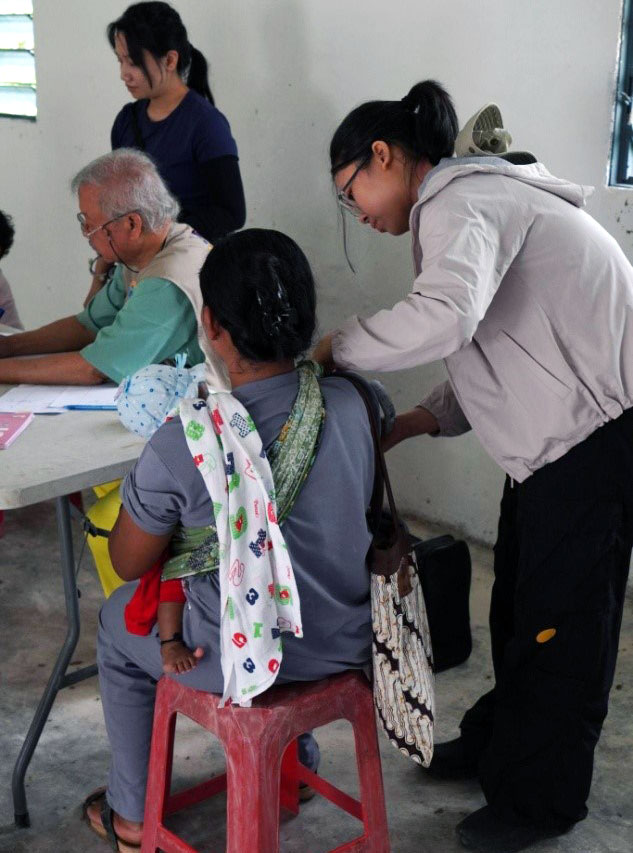 Medical student Jesselyn measuring blood pressure of a local villager